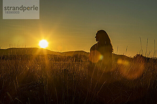 Sonnenuntergang-Silhouette-Ansicht einer Frau auf einem Feld in der Nähe von Sun Valley Idaho