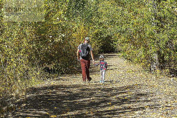Vater und Tochter gehen im Herbst auf einem ländlichen Weg in der Nähe von Sun Valley  Idaho