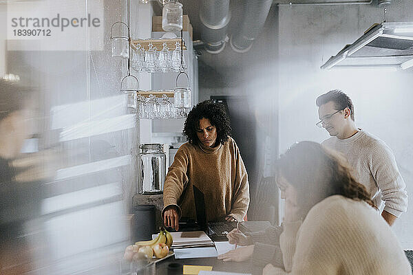 Multirassische männliche und weibliche Kollegen diskutieren in der Cafeteria am Arbeitsplatz