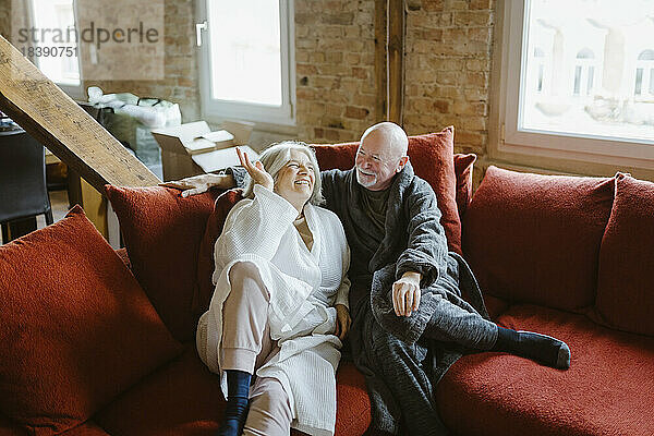 Glückliches älteres Paar verbringt seine Freizeit auf dem Sofa zu Hause