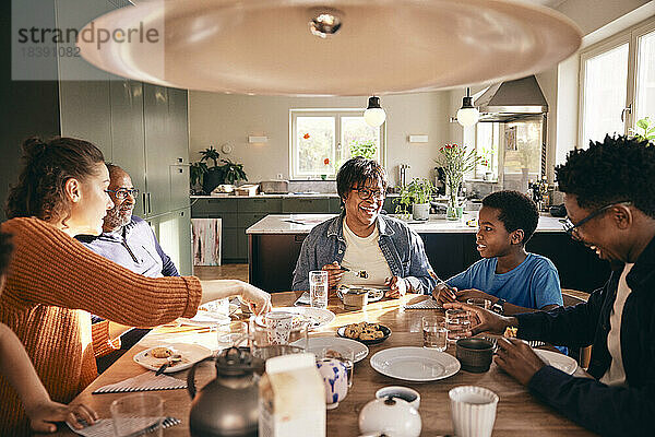 Eine gemischtrassige Familie genießt das gemeinsame Essen zu Hause