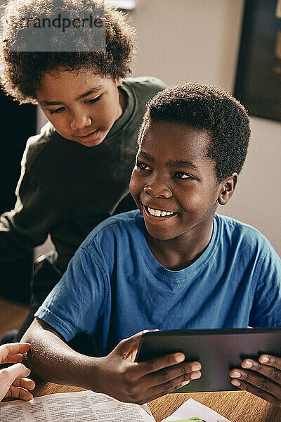Glückliche Brüder  die sich zu Hause mit einem digitalen Tablet vergnügen