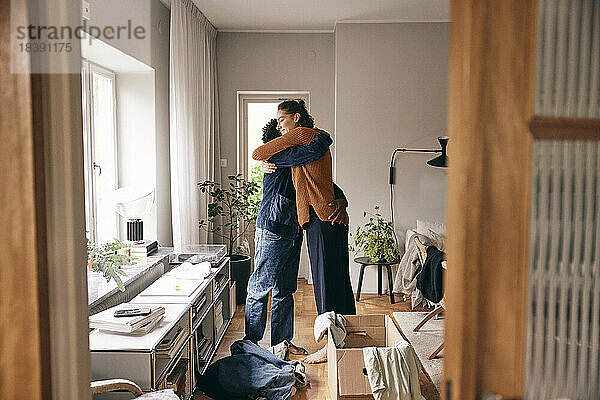 Seitenansicht eines Paares  das sich umarmt  während es zu Hause steht