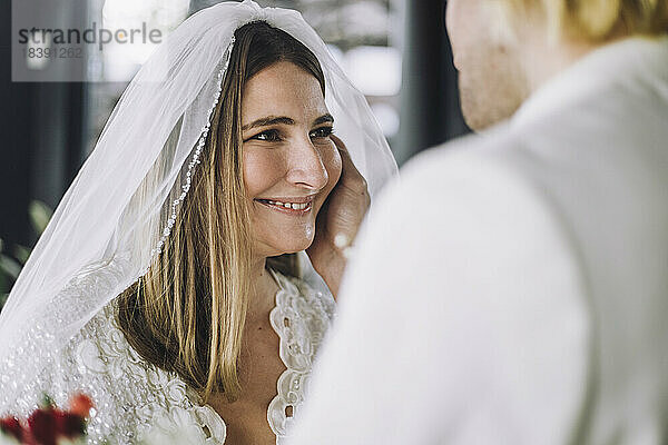 Glückliche Mitte erwachsene Braut im Hochzeitskleid Blick auf Bräutigam