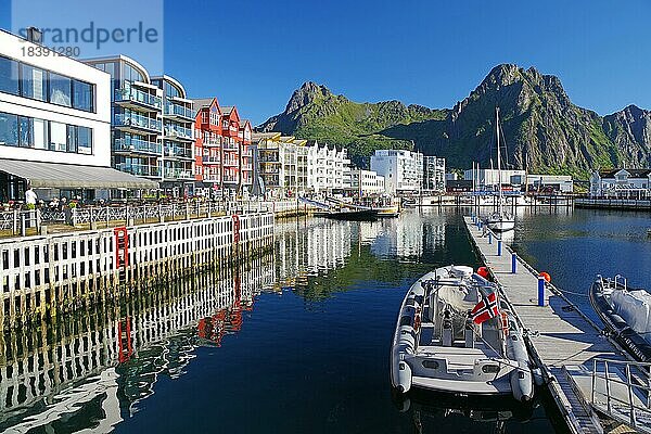 Moderne Häuser spiegeln sich im ruhigen Wasser des kleinen Hafen von Svolvaer  Lofoten  Nordland  Norwegen  Europa
