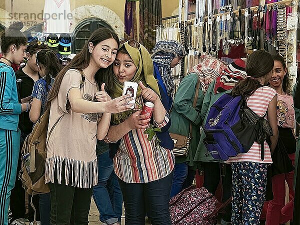 Beim Einkauf in einem Markt: zwei junge Schülerinnen  eine mit Kopftuch  machen lachend ein Selfie. Amman  Jordanien  Asien