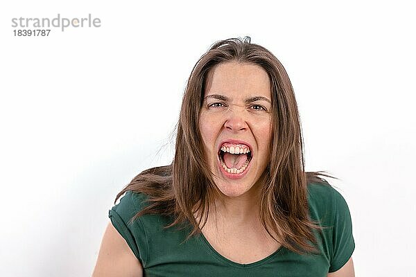 Nahaufnahme einer wütenden Frau  die in die Kamera schaut und ihre Zähne zeigt  auf weißem Hintergrund