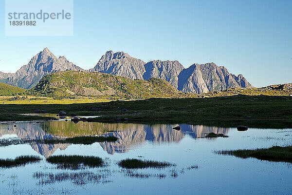 Hohe Berge spiegeln sich im ruhigen Wasser eines Sees  Sommer  Stille  Klarheit  Festvagtind  Austvagsoya  Provinz Nordland  Norwegen  Europa