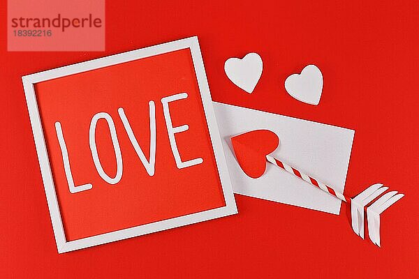 Valentinstag Komposition mit Bilderrahmen mit Text LIEBE  Amor Liebe Pfeile  Brief  und Herzen auf rotem Hintergrund