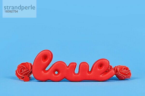 Valentinstag Dekoration mit roten Wort Liebe auf blauem Hintergrund