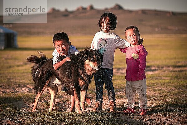 Einheimische Kinder spielen den ganzen Tag mit ihrem Hund  Mongolei  Asien