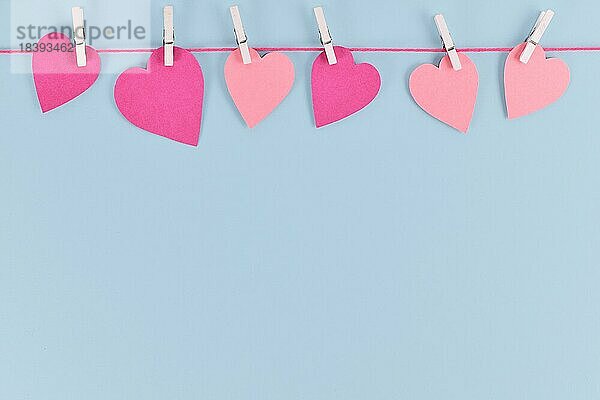 Einfache Valentinstag Hintergrund mit rosa Papier Herzen hängen von Linie mit Klammern mit leeren Kopie Raum