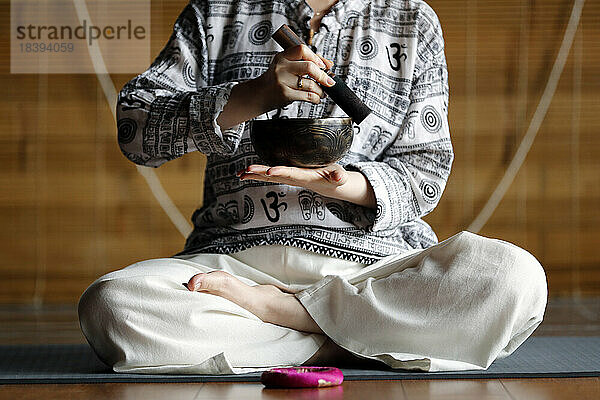 Tibetische Schale  buddhistische Frau beim Üben einer Klangschale für die Klangtherapie in einer Atmosphäre für Heilung  Meditation  Yoga und Entspannung  Quang Ninh  Vietnam  Indochina  Südostasien  Asien