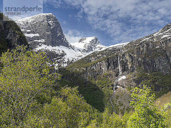 Blick auf einen Wasserfall an einer steilen Bergwand mit dem Myklebustbreen-Gletscher an der Spitze  Vestland  Norwegen  Skandinavien  Europa