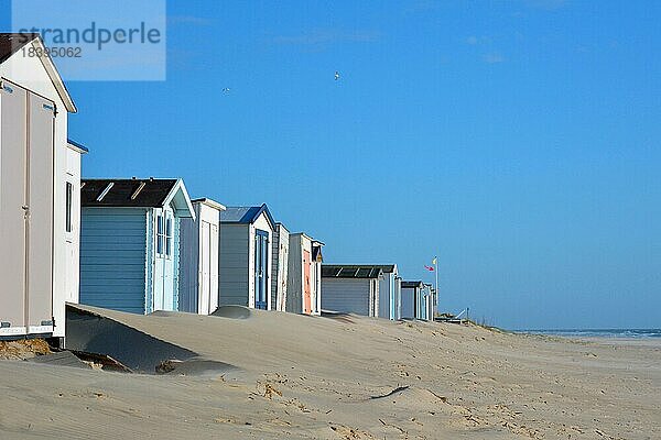Reihe von Strandhütten am Strand der Insel Texel in den Niederlanden mit blauem Himmel an einem sonnigen Tag  mit Fokus auf einen Teil der Hütte auf der rechten Seite und unscharfen Hintergrund mit Kopie Raum