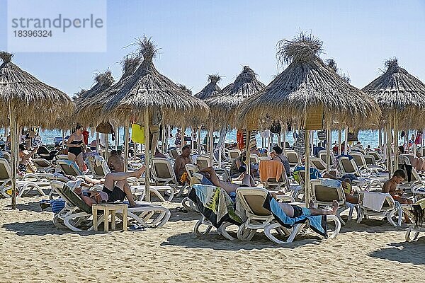 Sonnenanbeter auf Liegestühlen unter Sonnenschirmen am Strand von Golem  Plazhi i Golemit im Sommer  Sandstrand südlich der Stadt Durrës  Nordalbanien