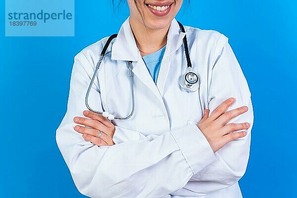 Porträt einer lächelnden Ärztin im Arztkittel  vorblauem Grund  Medizin Konzept  nicht erkennbare Person