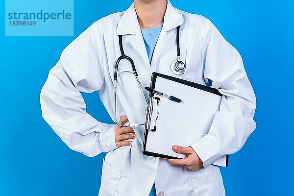 Porträt einer lächelnden Ärztin im Arztkittel  vorblauem Grund  Medizin Konzept  nicht erkennbare Person