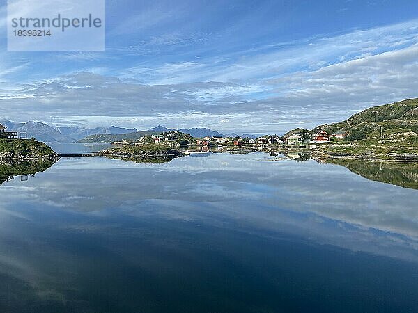 Glasklares Wasser und Holzhäuer spiegeln sich im Wasser  Insel Sommarøy  Sommer  hohe Berge  Tourismus  Troms  Provinz Troms og Finnmark  Norwegen  Europa