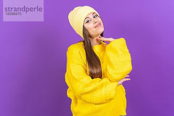 Close up Porträt einer jungen  fröhlichen Frau vorlila Studio Hintergrund in gelben Wollpullover