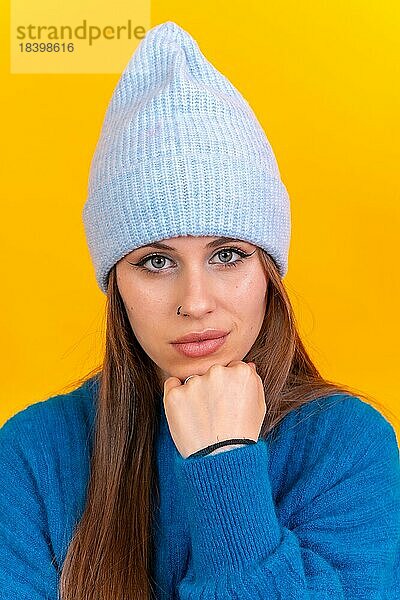 Close up Porträt einer jungen kaukasischen Frau trägt blaue Wolle Pullover vor Hintergrund  Blick in die Kamera
