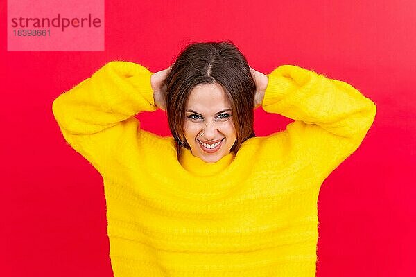Close up Porträt der jungen Frau  fröhlich vorroten Studio Hintergrund in gelben Wollpullover