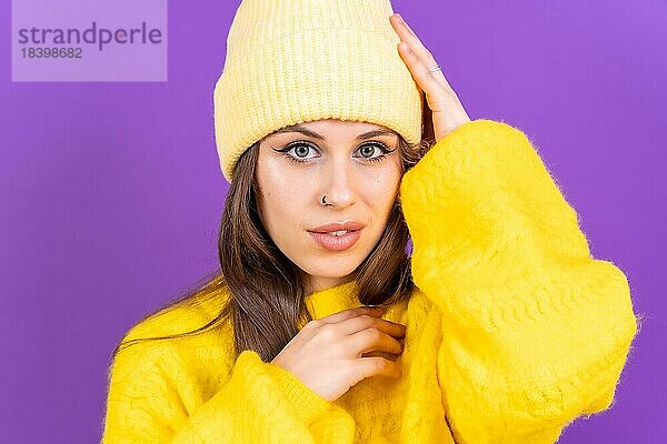 Close up Porträt der jungen kaukasischen Frau in gelben Wollpullover vor gelbem Hintergrund  Blick in die Kamera