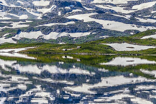 Spiegelung teilweise schneebedeckter Berge im See Stavatn im Haukelifjell  Hardangervidda  Norwegen  Europa
