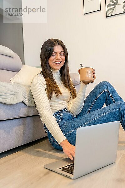 Porträt der Frau mit einem Computer sitzt auf einem Sofa mit einem heißen Kaffee  Millennial  soziale Netzwerke  Blog