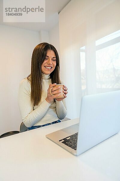Geschäftsfrau arbeitet an einem Computer mit einem heißen Kaffee  Geschäft  Heimbüro  Telearbeit