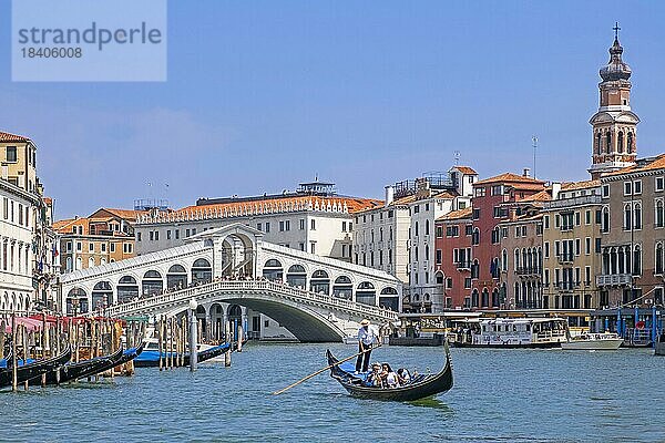 Ponte di Rialtobrücke über den Canal Grande und Gondoliere in traditioneller Gondel mit Touristen in Venedig  Veneto  Norditalien