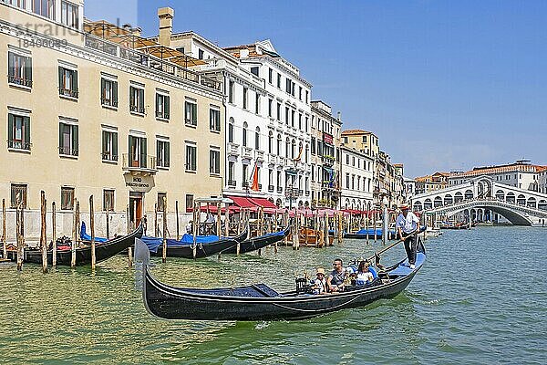 Ponte di Rialtobrücke über den Canal Grande und Gondoliere in traditioneller Gondel mit Touristen in Venedig  Veneto  Norditalien