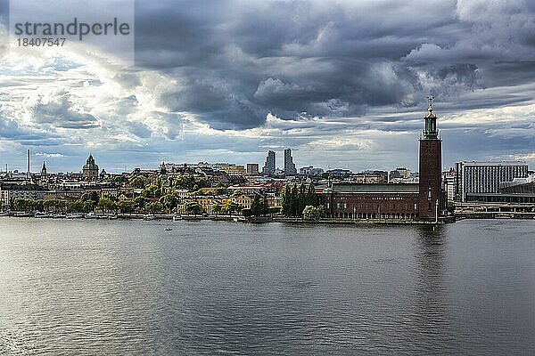 Blick vom Aussichtspunkt Monteliusvägen auf die Insel Kungsholmen mit Rathaus Stockholms stadshus  dramatischer Wolkenhimmel  Stockholm  Mälaren  Schweden  Europa