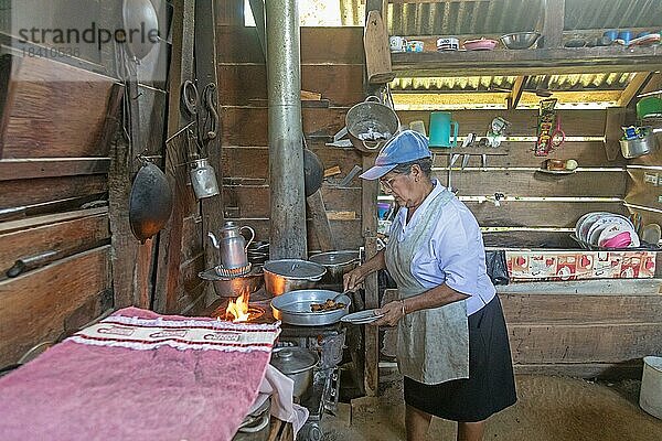 Muelle San Carlos  Costa Rica  Eine Frau kocht über einem Holzofen in einem ländlichen Bauernhaus  Mittelamerika