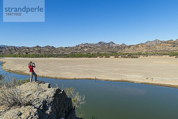 Frau fotografiert am Orange River  auch Oranje-Fluss  an der Grenze zwischen Namibia und Südafrika  Oranjemund  Sperrgebiet Nationalpark  auch Tsau ?Khaeb Nationalpark  Namibia  Afrika