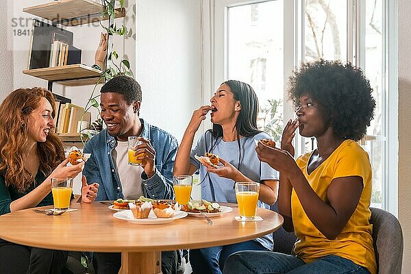 Freunde bei einem Frühstück mit Orangensaft und Muffins zu Hause  gesunder Lebensstil mit Spaß am Morgen