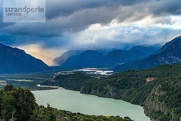 Sonnenstrahlen durchbrechen die Regenwolken über dem Fluss-Tal des Rio Ibanez  Cerro Castillo-Nationalpark  Aysen  Patagonien  Chile  Südamerika