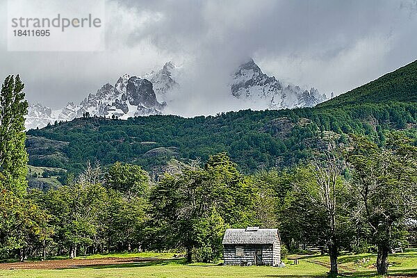 Mit Schindeln gedecktes Holzhaus vor schneebedeckten Bergen  Villa Cerro Castillo  Cerro Castillo-Nationalpark  Aysen  Patagonien  Chile  Südamerika