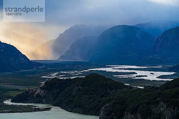 Sonnenstrahlen durchbrechen die Regenwolken über dem Fluss-Tal des Rio Ibanez  Cerro Castillo-Nationalpark  Aysen  Patagonien  Chile  Südamerika