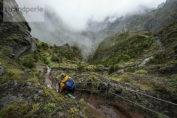 Wanderin  Pico Arieiro zum Pico Ruivo Wanderung  Wanderweg an Felsenklippe  Zentralgebirge Madeiras  Madeira  Portugal  Europa