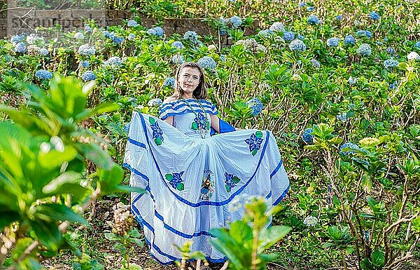 Porträt einer jungen Nicaraguanerin in traditioneller Volkstracht in einem Blumenfeld  Nicaraguanerin in traditioneller Volkstracht in einem Blumenfeld