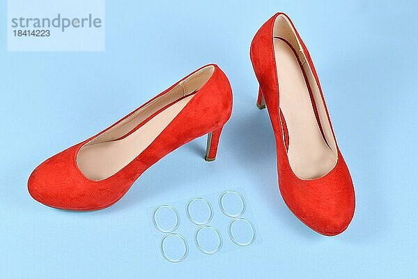 Schuhsohlenschutz Gel Aufkleber zur Entlastung von Druckstellen neben roten High Heels auf blauem Hintergrund