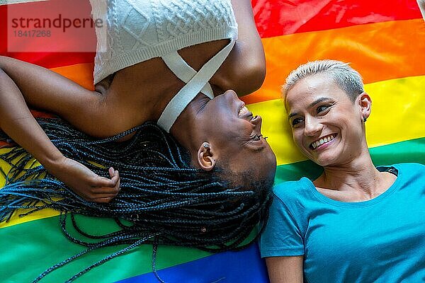 Schöne lesbische Paar über Regenbogenflagge  lgbt Konzept  romantische Pose