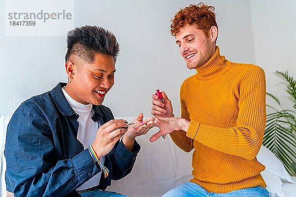 Schönes homosexuelles Paar  das sich schminkt  sich die Nägel lackiert und lächelt  wenn es drinnen zu Hause romantisch ist  lgbt Konzept