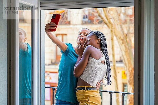 Schöne lesbische Paar umarmt ein Selfie auf dem Balkon zu Hause  lgbt Konzept
