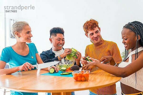 Eine Gruppe von Freunden bereitet einen Salat zu. Sie bereiten Essen zu und haben Spaß in der Küche