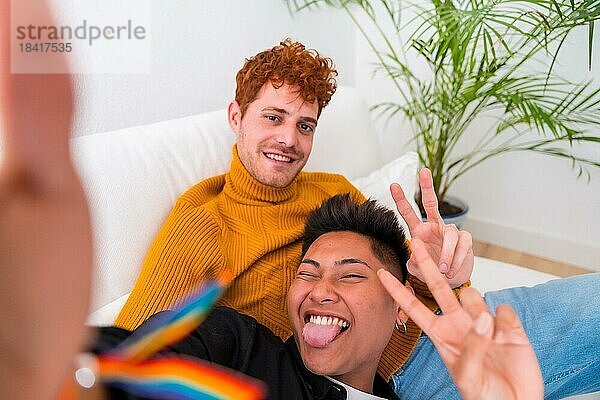 Schöne Homosexuelles Paar romantisch zu Hause auf dem Sofa  Homosexuelles Paar  die selfie und machen Sieg Zeichen  lgbt Konzept