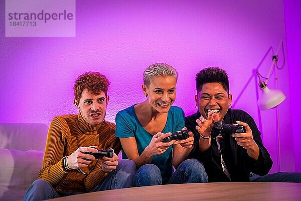 Eine Gruppe junger Freunde  die zusammen auf dem Sofa zu Hause Videospiele spielen  lila gekleidet  mit viel Spaß beim Schieben