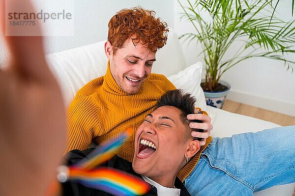 Schönes homosexuelles Paar  das drinnen zu Hause auf dem Sofa romantisch ist  homosexuelles Paar  das Selfie lachend macht  lgbt Konzept