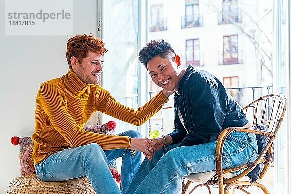 Porträt der schönen Homosexuell Paar wird romantisch zu Hause auf dem Balkon halten die Hände  lgbt Konzept
